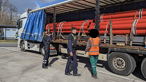Foto zum Thema "Wie wird man Polizist*in": Zu sehen sind Svenja und ihr Kollege bei einer LKW-Kontrolle auf einem Autobahnparkplatz.