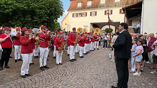 Foto zum Thema "Wie wird man Bürgermeister": Rechts im Bild steht Joachim, links spielt eine Musikkapelle.
