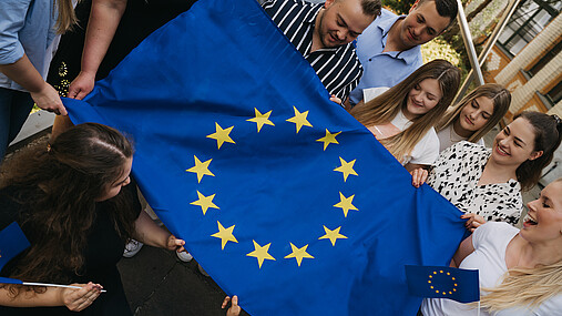 Foto zum Thema "Europatag 2026": Zu sehen sind Mitglieder der dbb jugend mit einer großen Europafahne.
