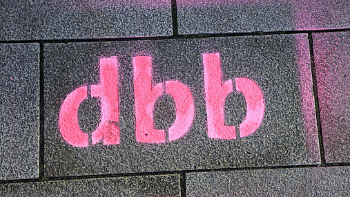 Foto zum Thema "Tarifverhandlungen in Hessen": Zu sehen ist ein dbb-Logo, das auf den Asphalt gespayt wurde.