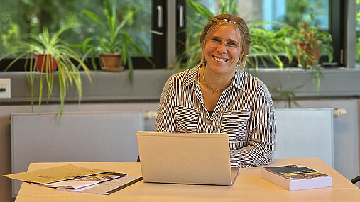 Foto zum Thema "Wie wird man Bewährungshelfer*in?": Zu sehen ist Lea, die am Laptop sitzt. Im Jobkompass gibt sie Einblicke in ihren Beruf.